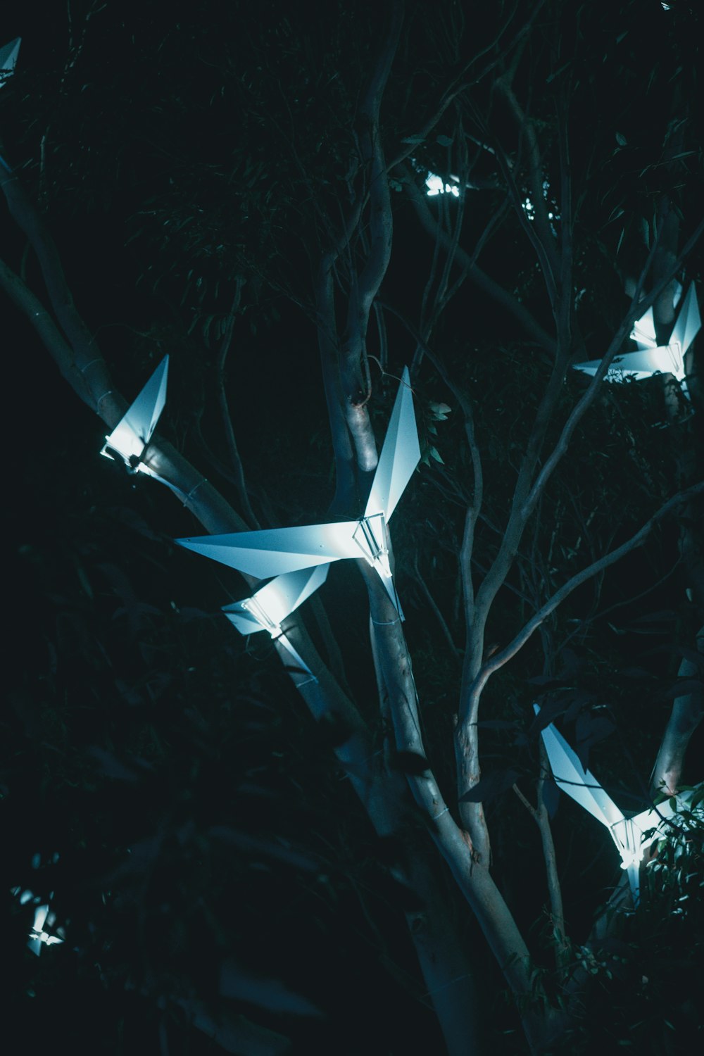 a group of origami birds flying in the night sky