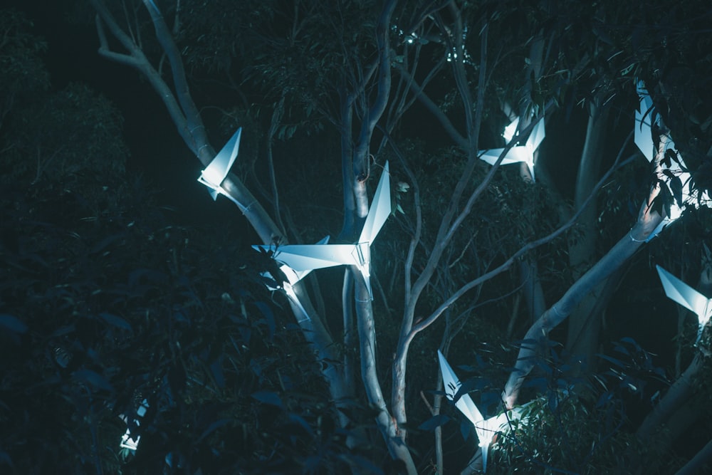 a group of origami birds in a tree at night