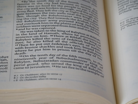 An open book displaying a page with two columns of text, written in a formal, structured format typical of biblical or historical documents. The text includes references to historical events and figures. The edges of the pages are slightly curled, indicating use.