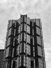 A panoramic shot of a luxury residential building mid-construction, featuring smooth metallic finishes and sharp angles.