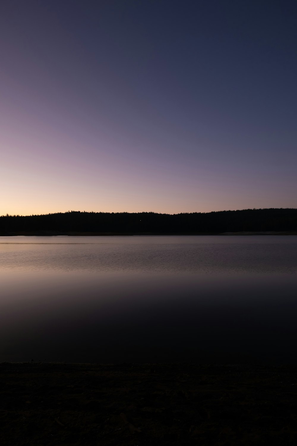 a large body of water sitting under a purple sky