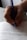 A close-up of a hand holding a blue pen, writing on lined paper. The handwriting is visible, with some text oriented horizontally.