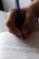 Close-up of hands writing notes during an English language class.