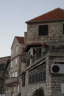 Historic stone buildings with charming balconies adorned with flowers, capturing Cap Valéor's timeless architecture.