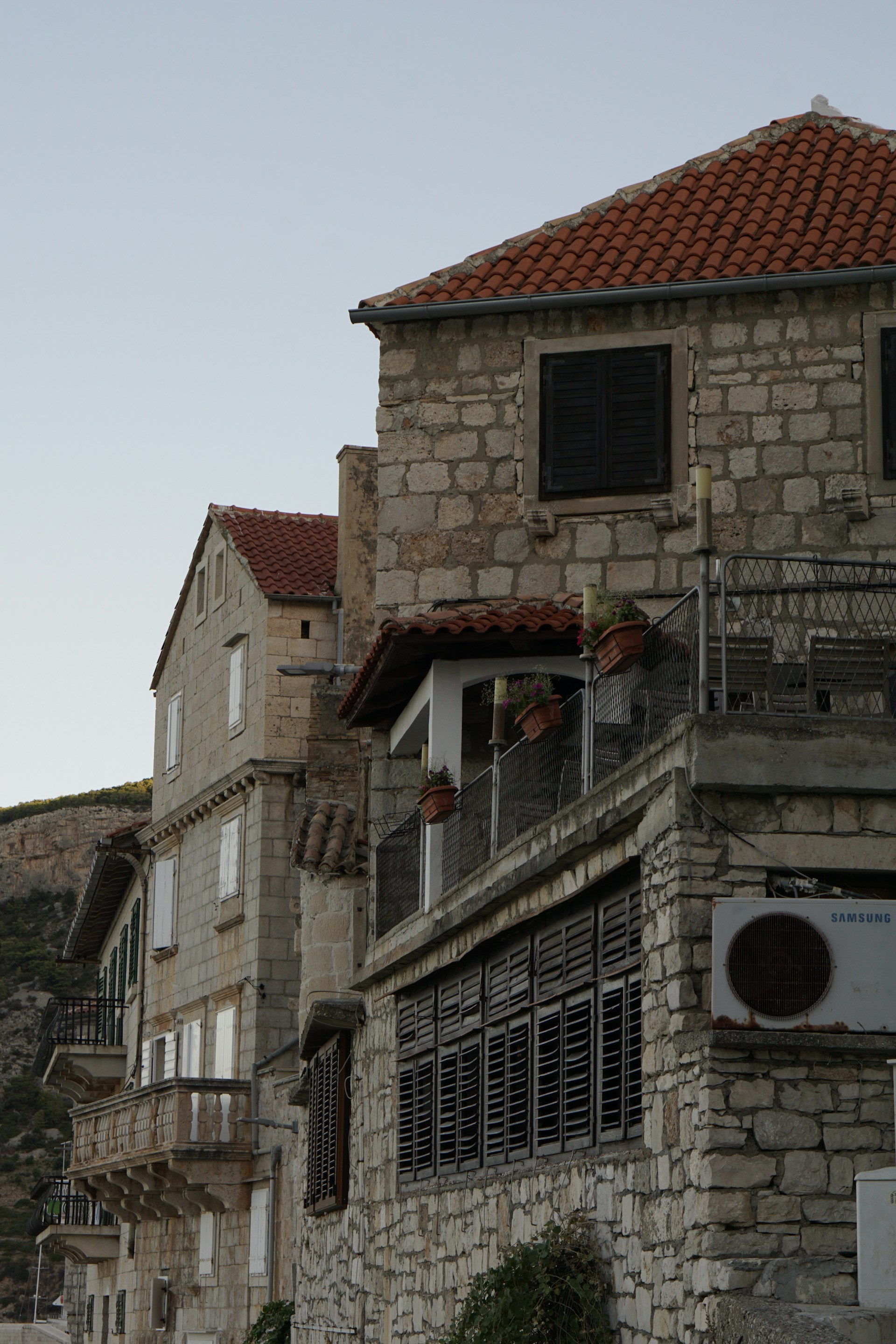 A candid moment of the cast sharing a laugh during a break, with traditional San Miguel architecture softly blurred in the background.