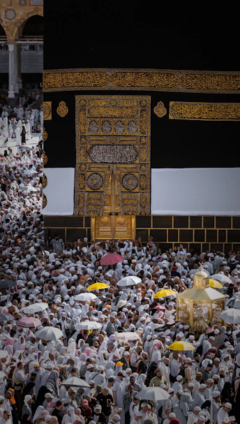 A crowd of people in white garments surrounding the Kaaba in Makkah, Saudi Arabia