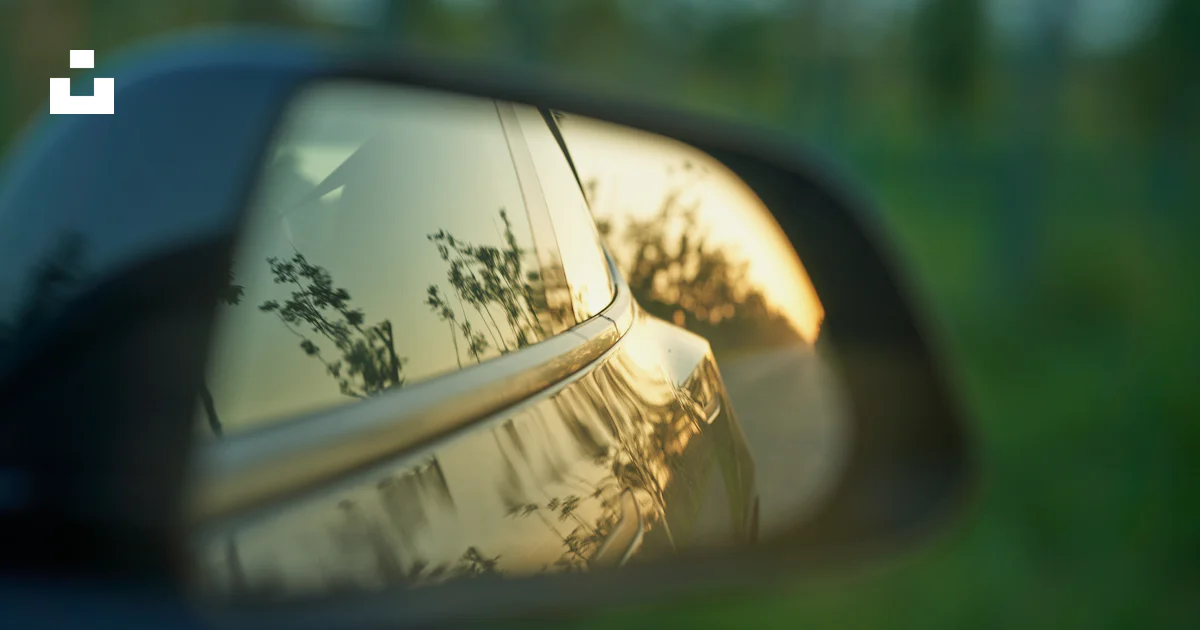 A Car s Side View Mirror Reflecting The Trees In The Rear View Mirror a-car-s-side-view-mirror-reflecting-the-trees-in-the-rear-view-mirror