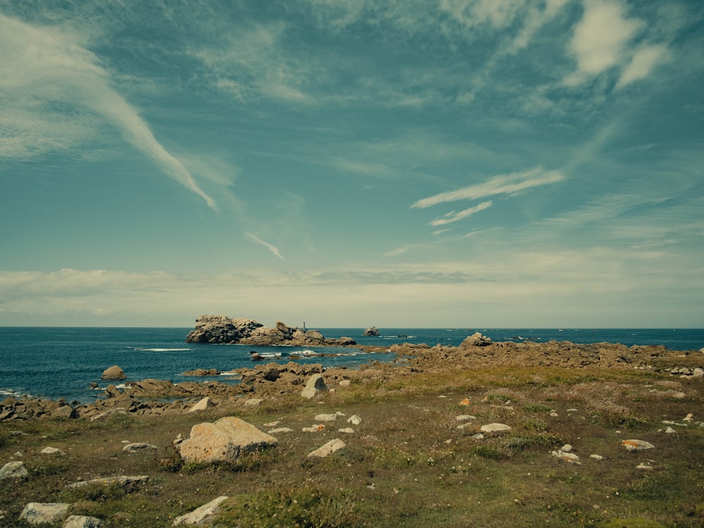 a large body of water sitting next to a rocky shore