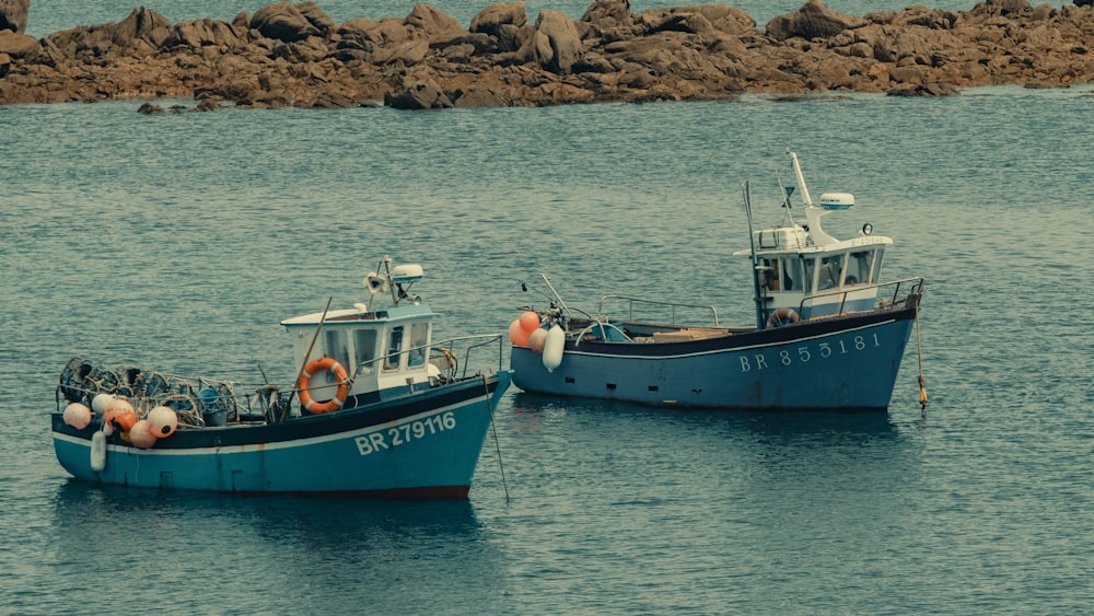 um par de barcos flutuando em cima de um corpo de água