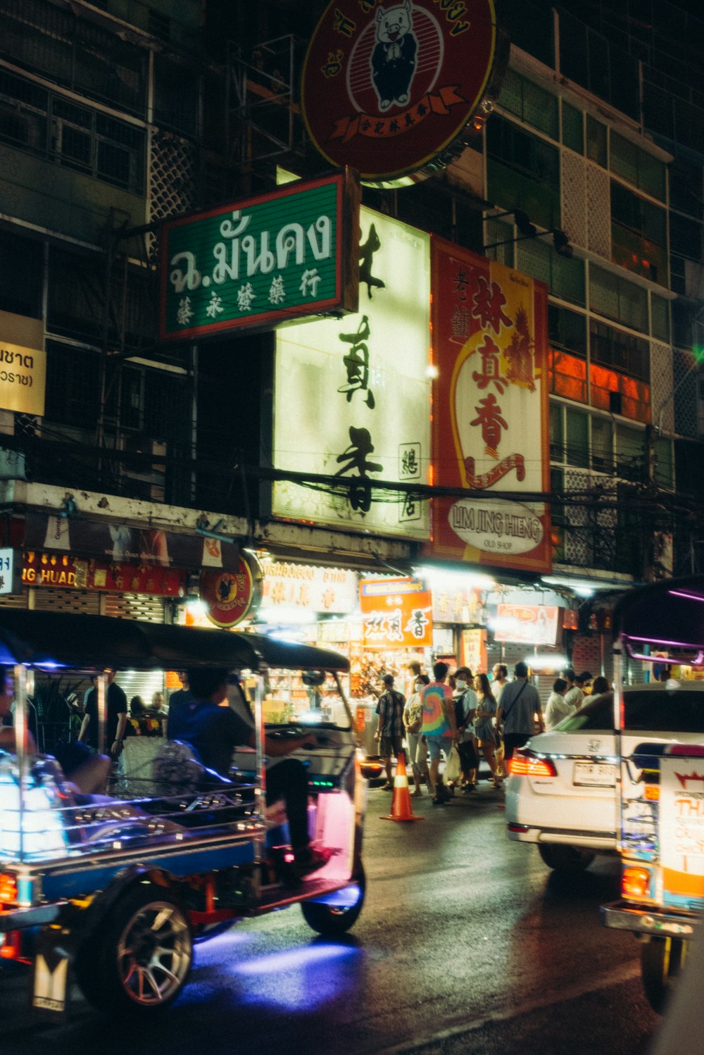 a busy city street at night with neon signs