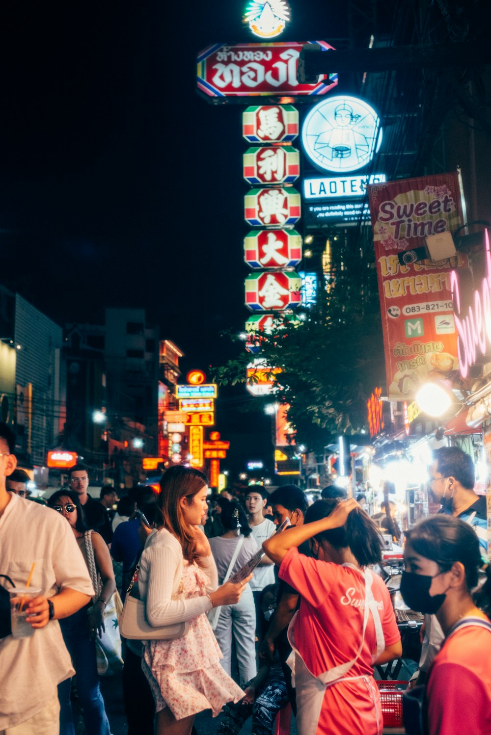 a group of people standing on a street at night