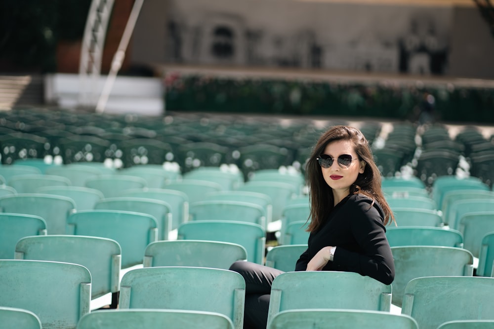 a woman sitting on a chair in a stadium