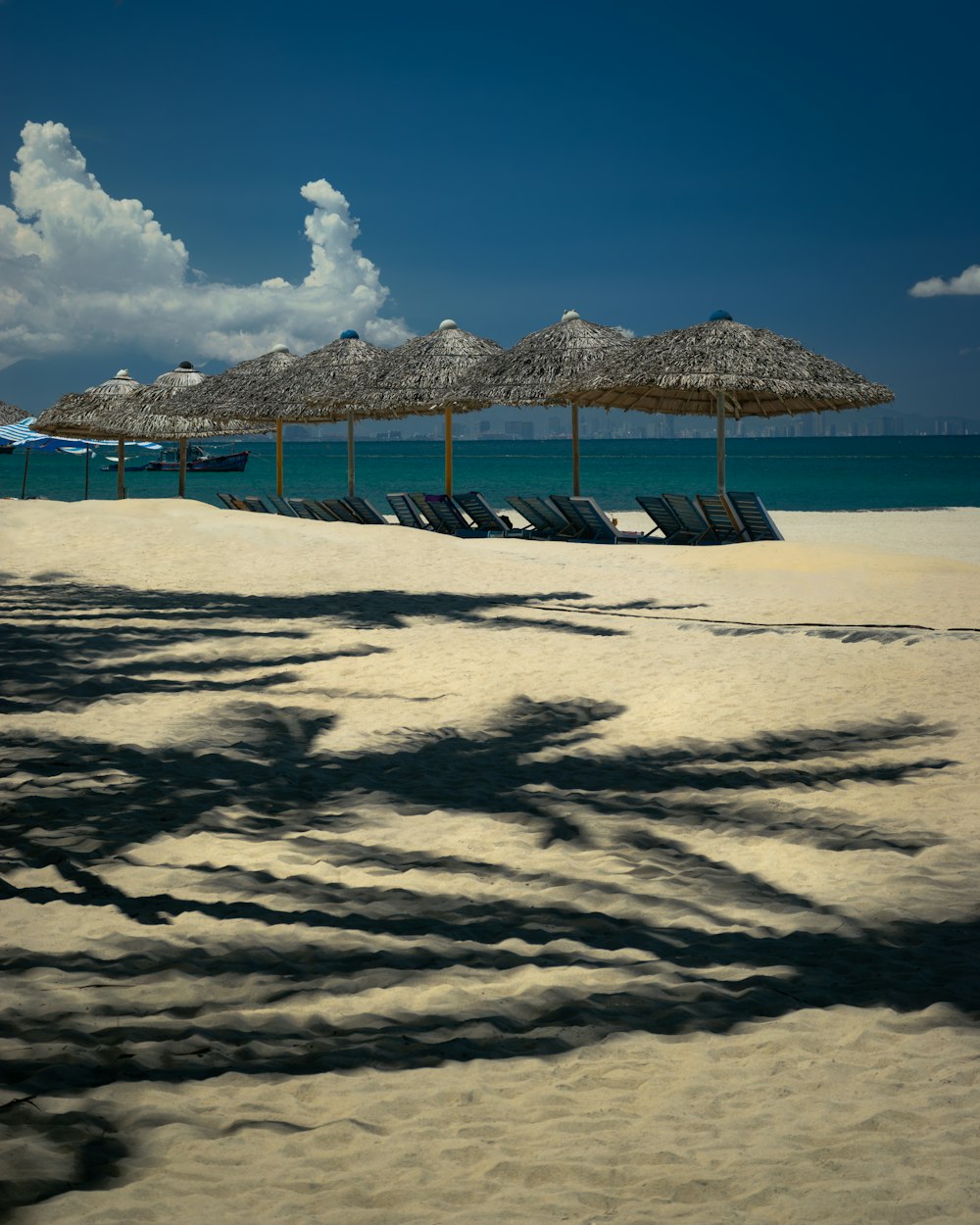ein Sandstrand mit Sonnenschirmen und Stühlen