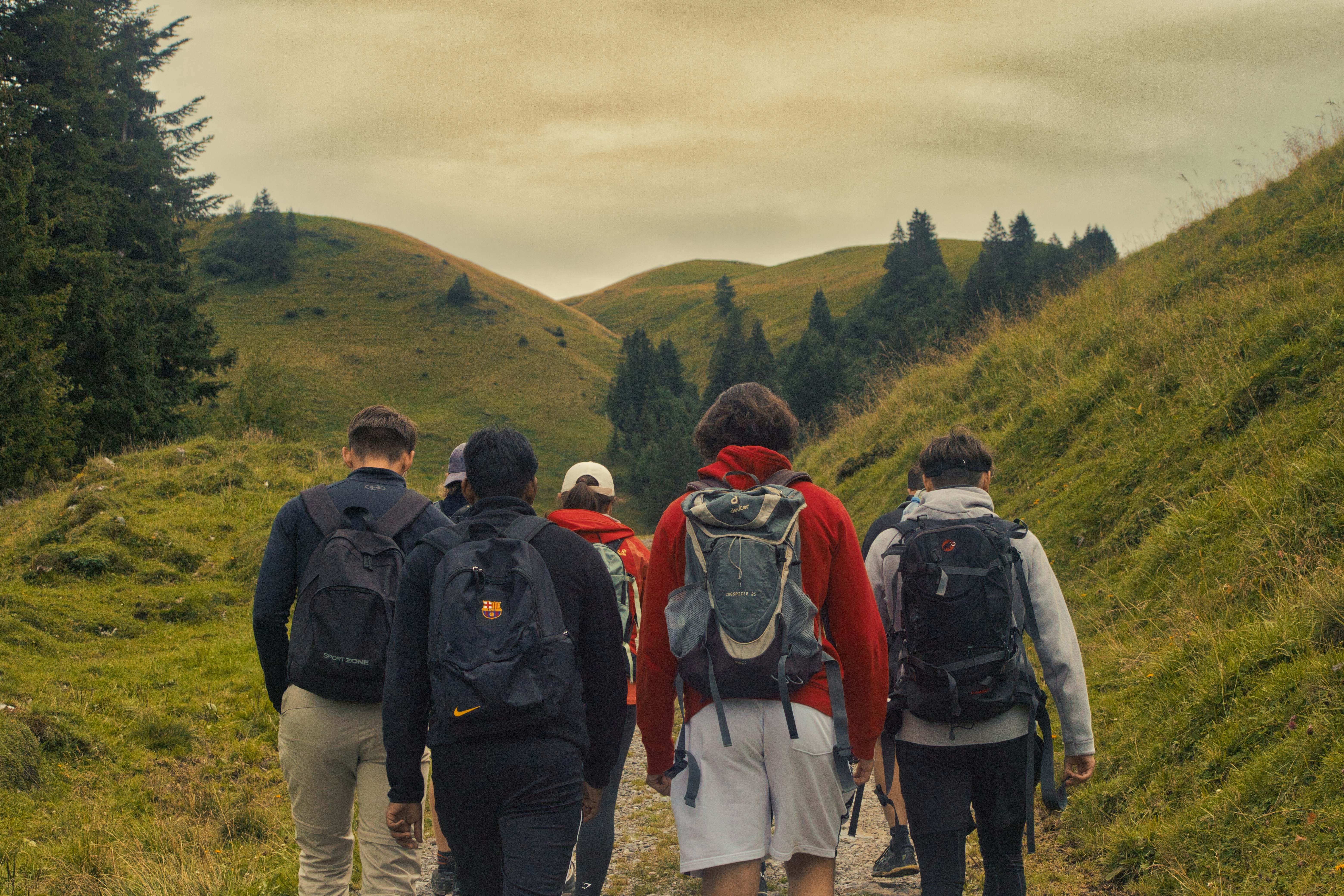 A group of people walking down a dirt road