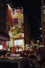 A vibrant city street scene at dusk with taxis in activity.