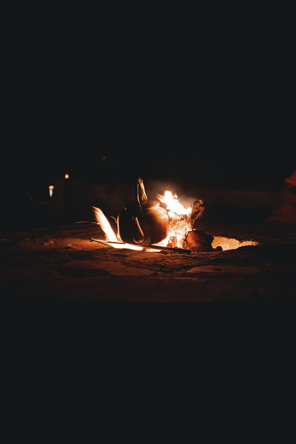 a person sitting in front of a fire in the dark