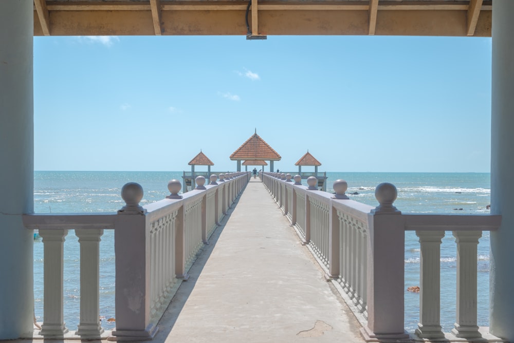 a walkway leading to the beach with a gazebo in the distance