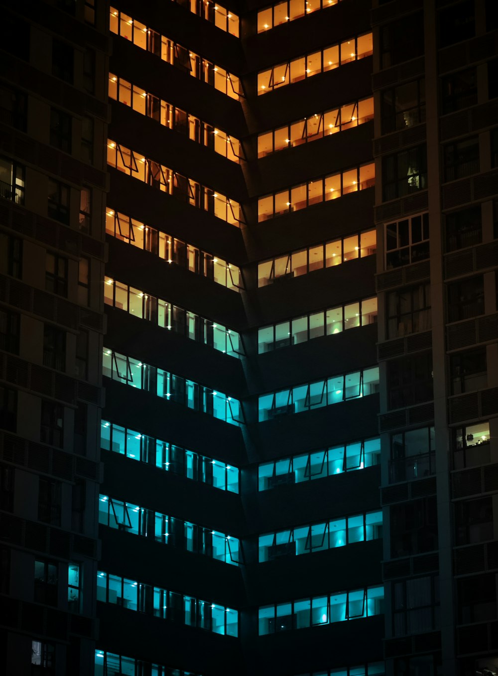 a very tall building with many windows lit up at night