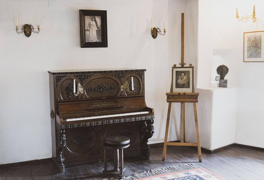a piano in a room with pictures on the wall