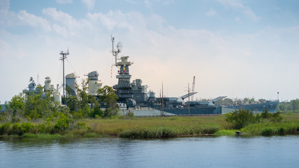 a large battleship sitting on top of a lush green field