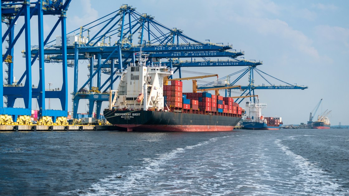 A large cargo ship in the water with a large crane in the background