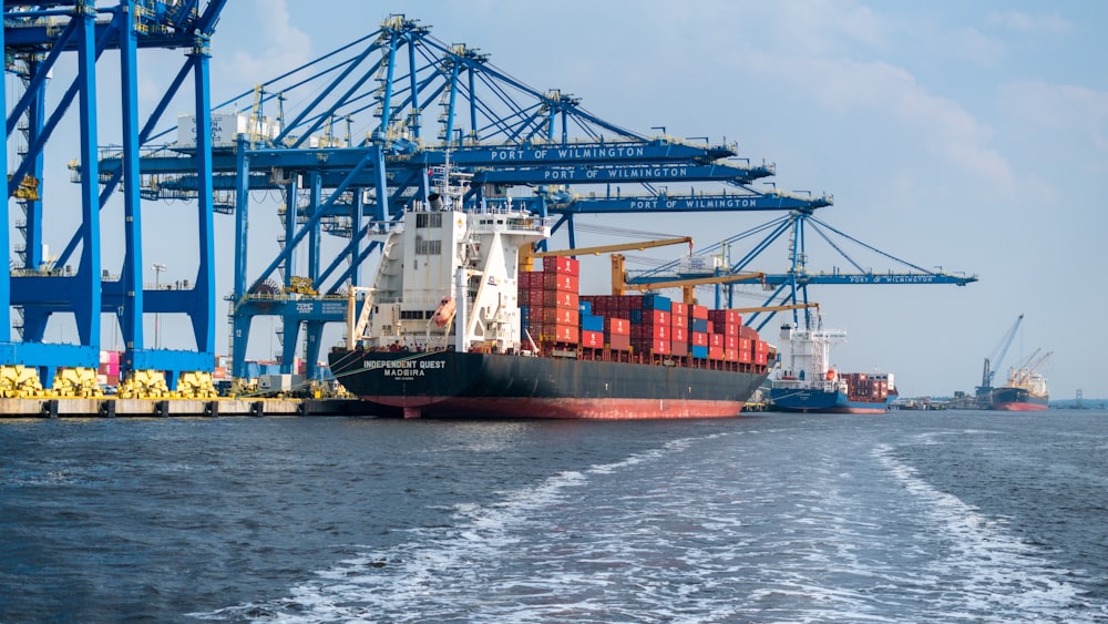 a large cargo ship in the water with a large crane in the background