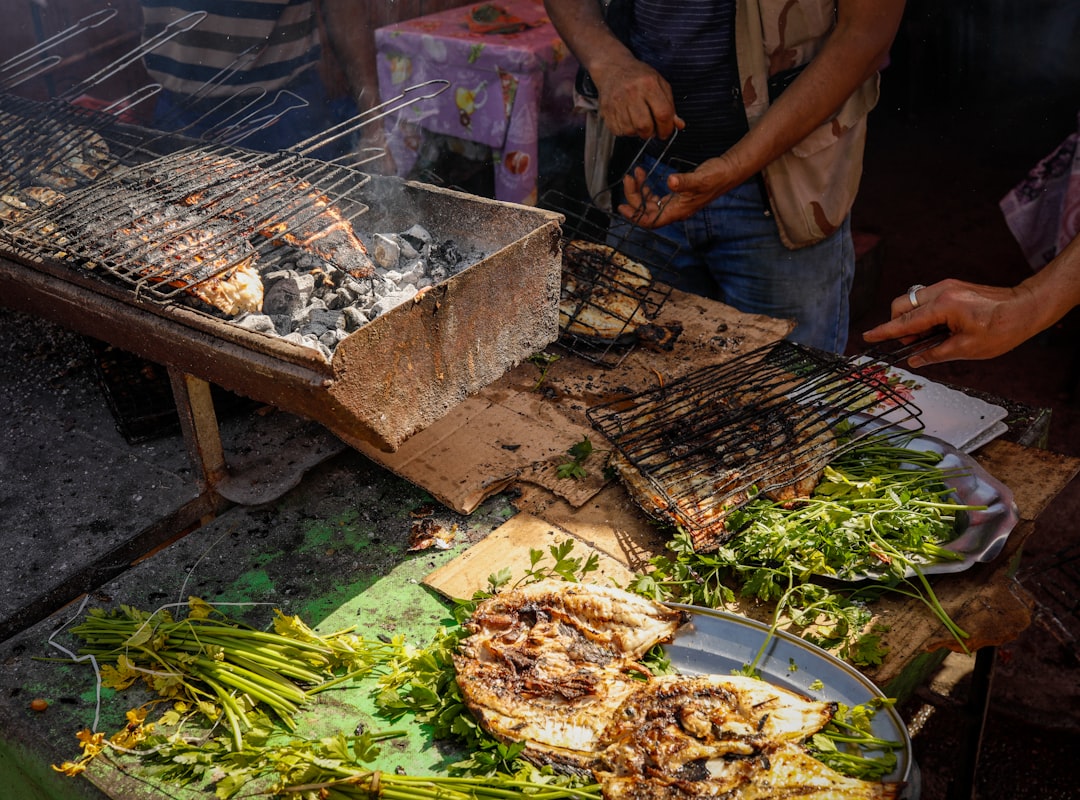 a man cooking food on a grill on a table,