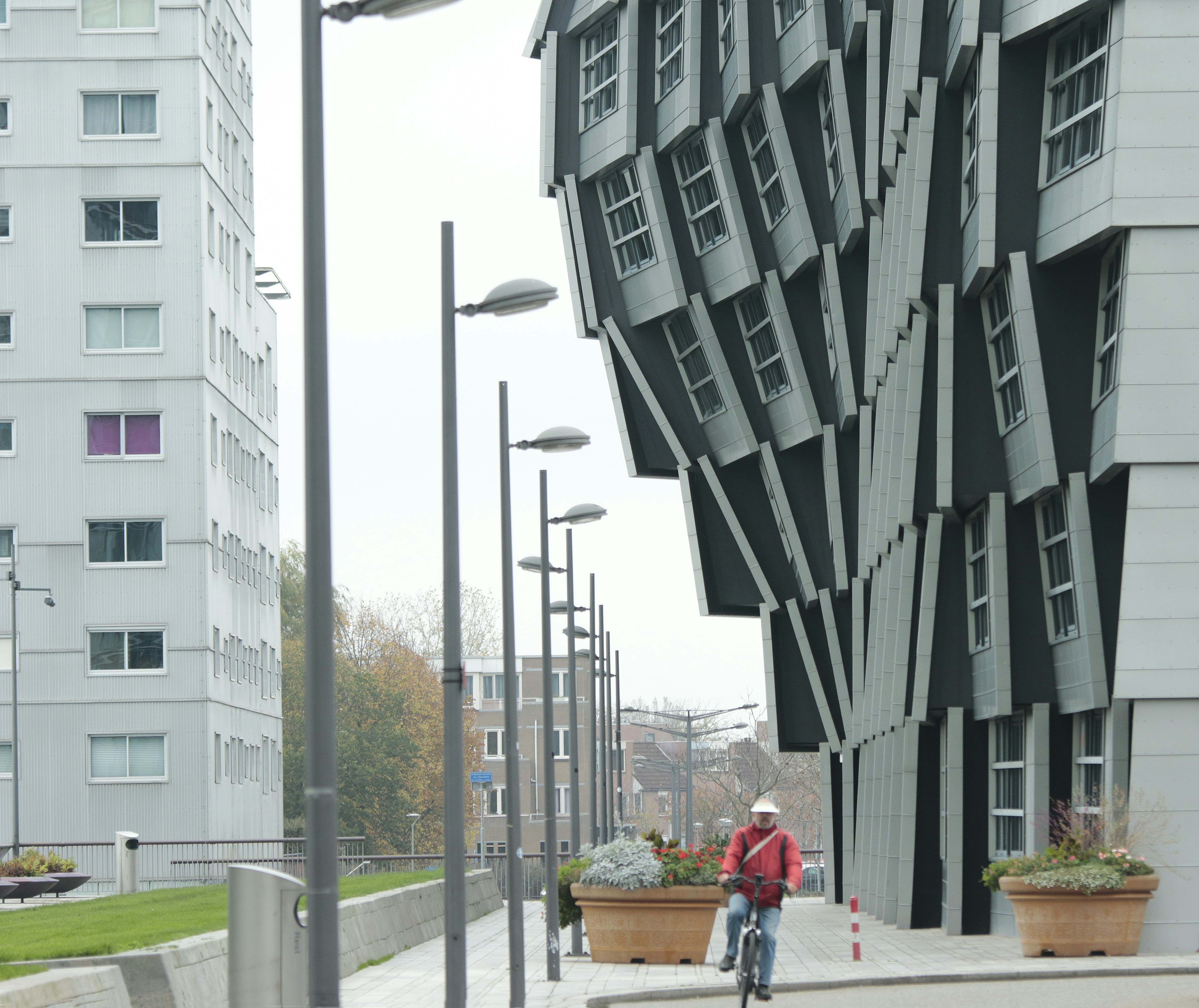 a man riding a bike down a street next to tall buildings