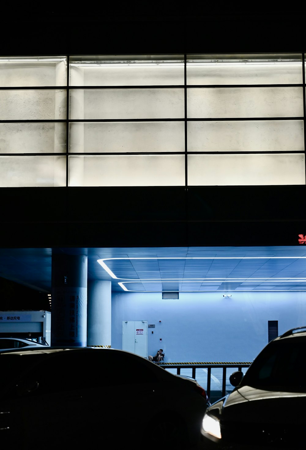 two cars parked in a parking garage at night