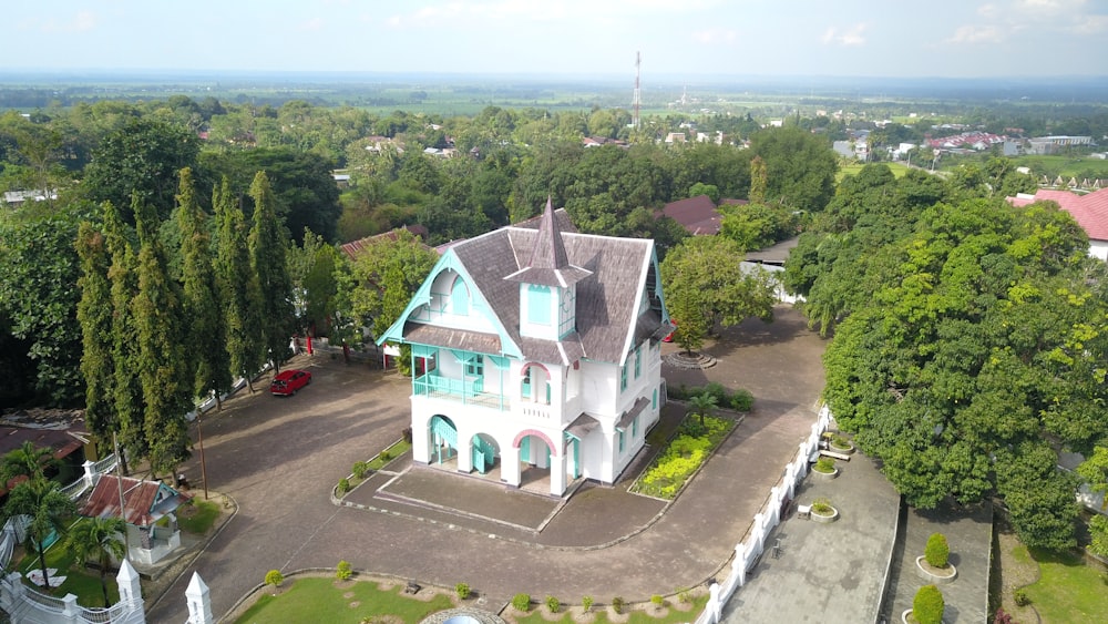 an aerial view of a large white house surrounded by trees