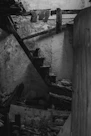 Close-up of warped wooden stairs dangerously sagging underfoot inside a poorly built home.