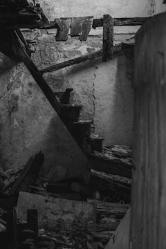 Close-up of warped wooden stairs dangerously sagging underfoot inside a poorly built home.