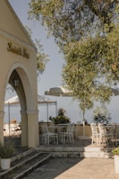 A peaceful outdoor patio with comfortable seating surrounded by lush greenery and gentle ocean breeze.