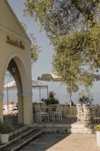 An outdoor patio space with stylish furniture and lush greenery under a clear sky.