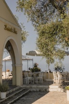 A cozy outdoor patio with waterproof curtains gently swaying in the breeze under a bright blue sky.