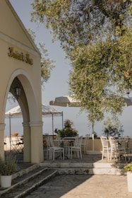 A breezy outdoor patio with soft cushions, sun hats, and potted succulents against a blue sky.