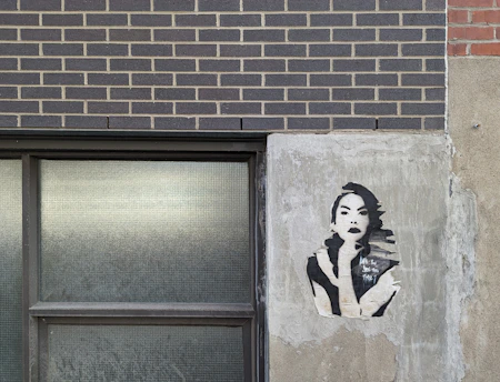 A striking close-up of a Banksy stencil artwork on a weathered urban wall, capturing the gritty essence of street art.
