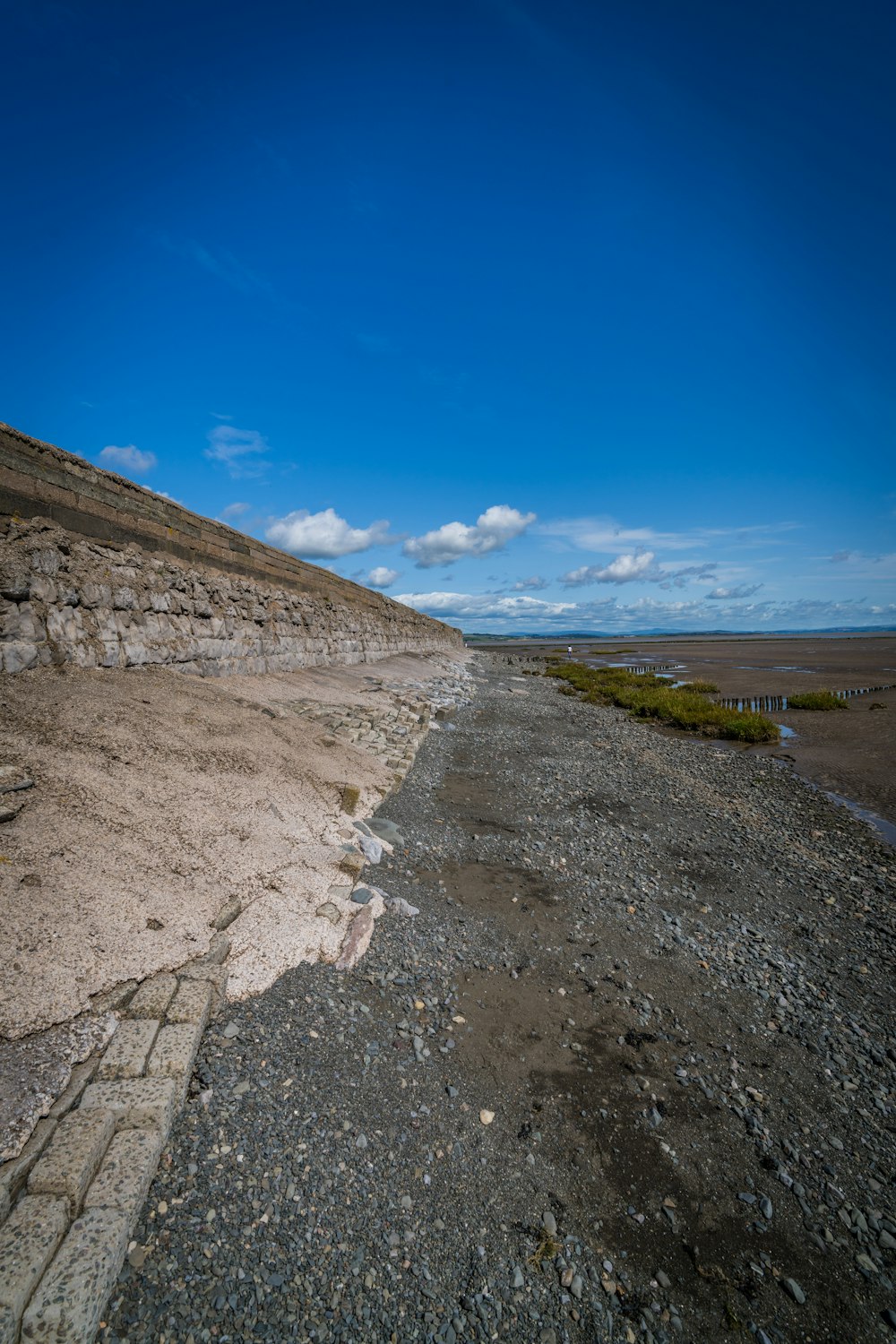 Une plage rocheuse avec un ciel bleu en arrière-plan