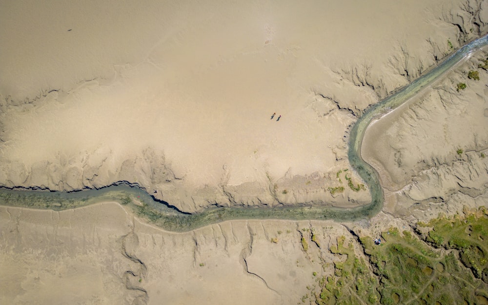 une vue aérienne d’une rivière traversant une zone sablonneuse