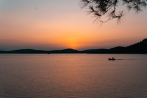 a boat in a body of water at sunset