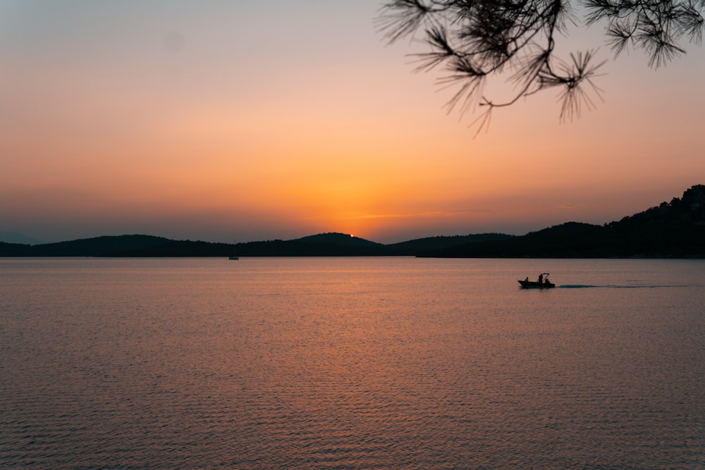 a boat in a body of water at sunset