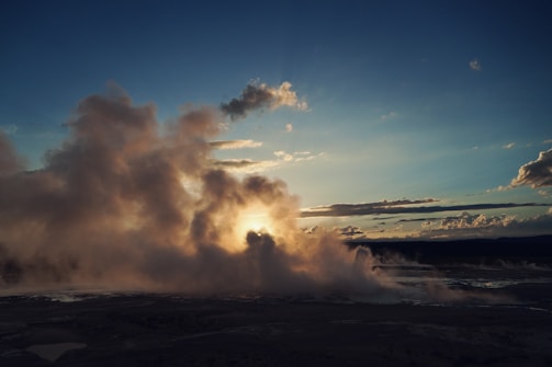 Sunset over Yellowstone Lake with steam rising from nearby hot springs.