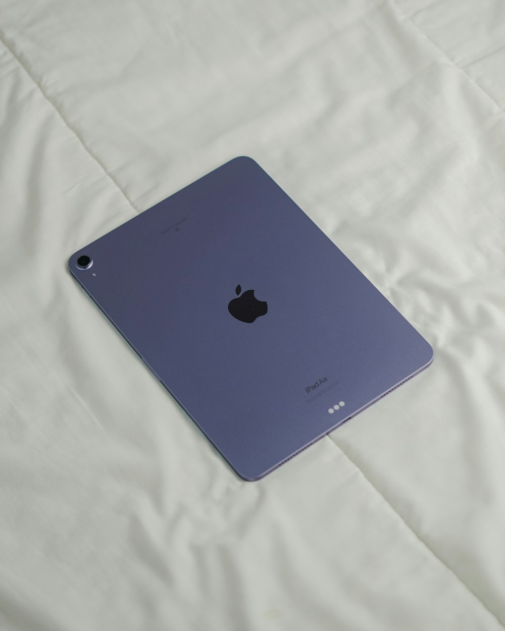 an apple ipad sitting on a white sheet