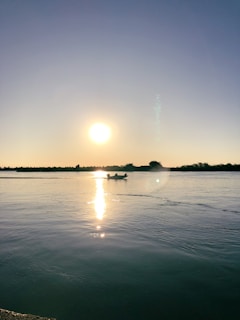 A serene rowing scene on a calm lake at sunset.