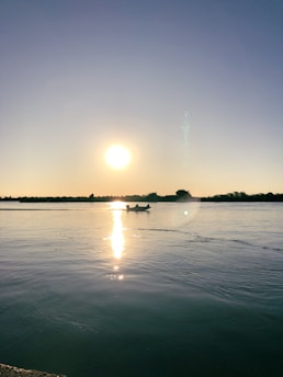 A serene rowing scene on a calm lake at sunset.