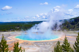 A vibrant sunrise over Old Faithful geyser erupting amidst the lush Yellowstone forest.