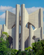 A modern sustainable building surrounded by green trees under a clear sky.