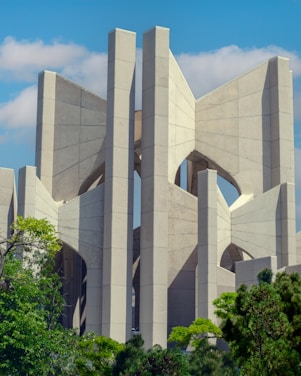 A panoramic view of a modern industrial building surrounded by greenery under a clear sky.