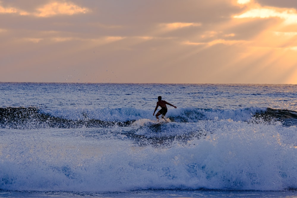 a man riding a wave on top of a surfboard