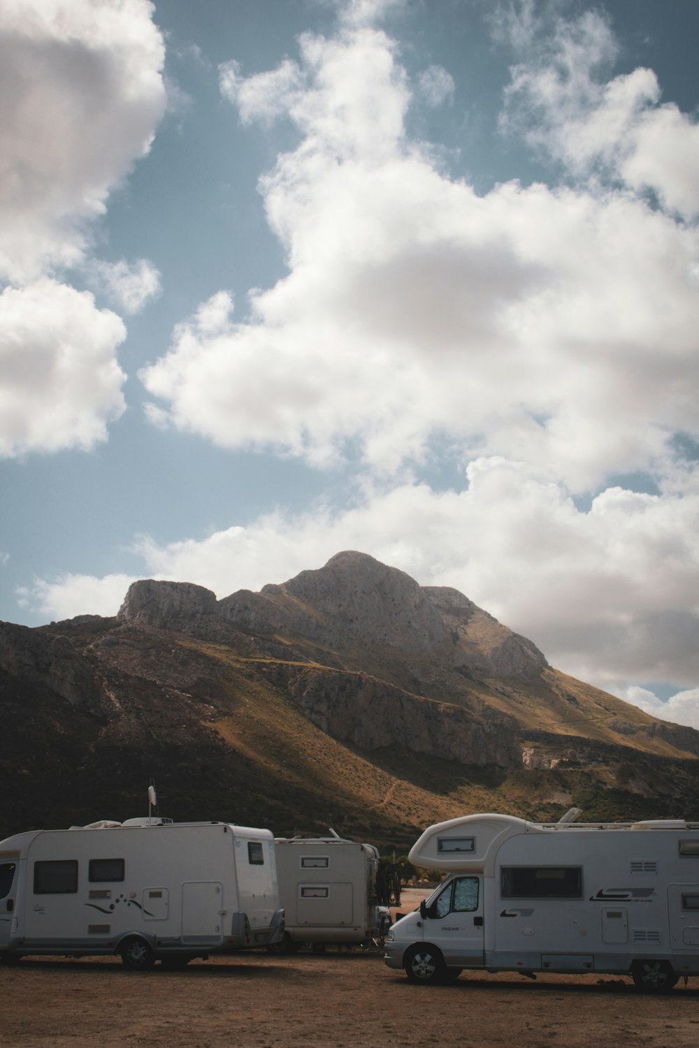 a couple of trucks parked next to a mountain